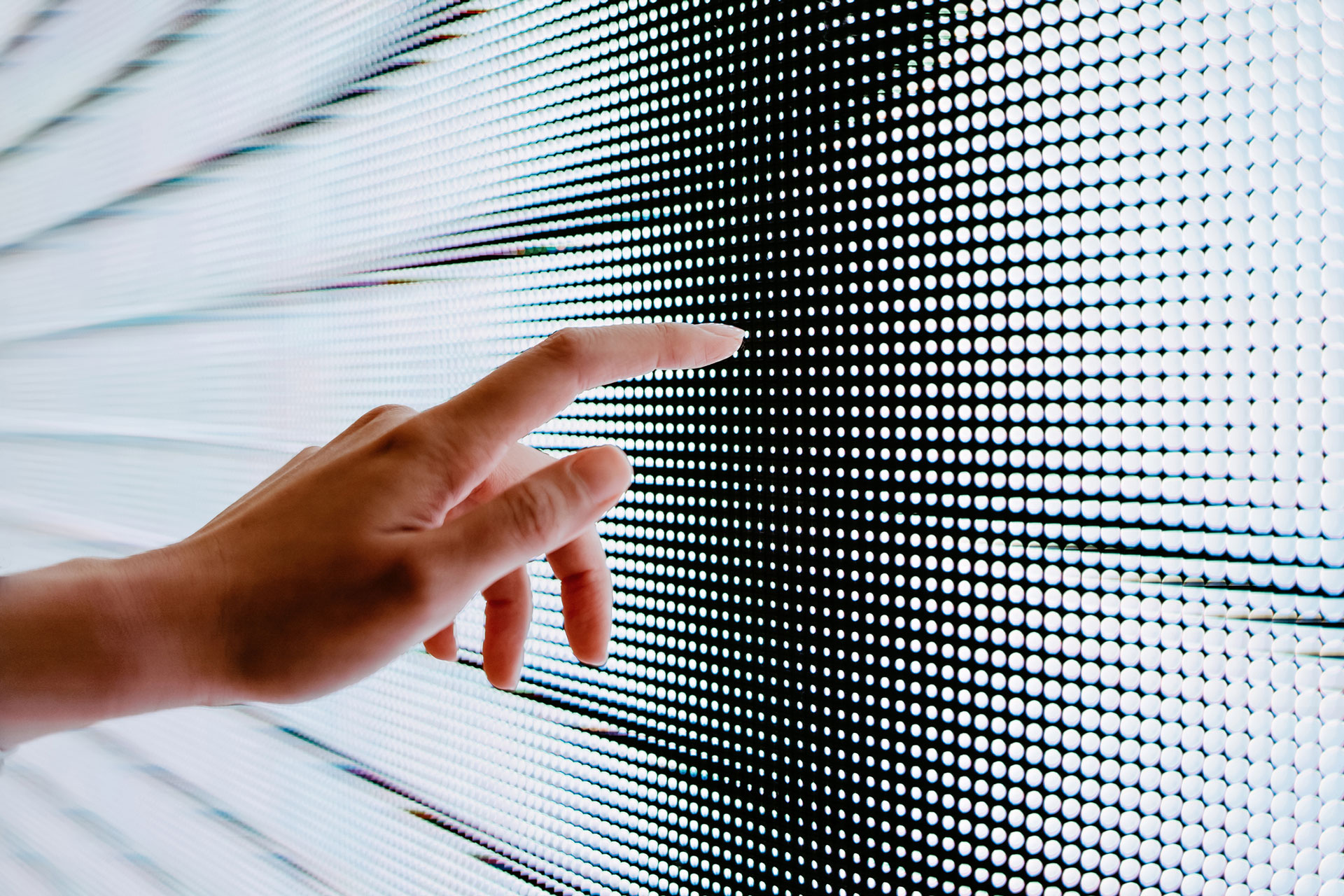 Close up of woman's hand touching illuminated LED display screen, connecting to the future | © d3sign @GettyImages