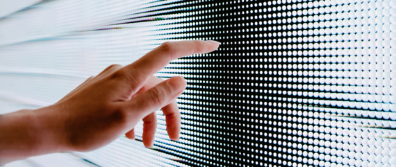 Close up of woman's hand touching illuminated LED display screen, connecting to the future | © d3sign @GettyImages