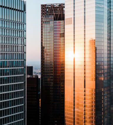 Business and finance concept, looking up at high rise office building architecture at night in the financial district of a modern metropolis. | © © 2021 R.M. Nunes