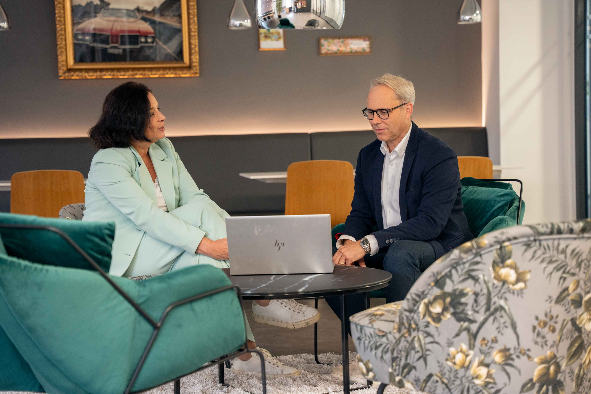 Sopra employees sitting at a coffee table with a laptop